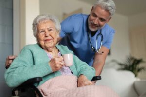 A senior resident receiving medication assistance from a staff caregiver in a cozy assisted living apartment.