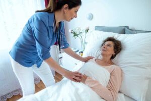 Older resident speaks with an interviewer in a bright assisted living common room beside a table and tea. KEYWORDS: ["assisted living resident interview", "senior daily routine", "assisted living common room"]